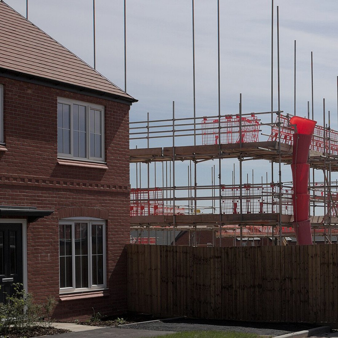 Scaffold and a rubble chute beside a brick house
